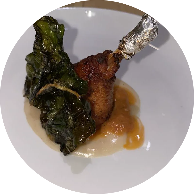 A crisp leg wrapped in charred greens, with a bright sauce